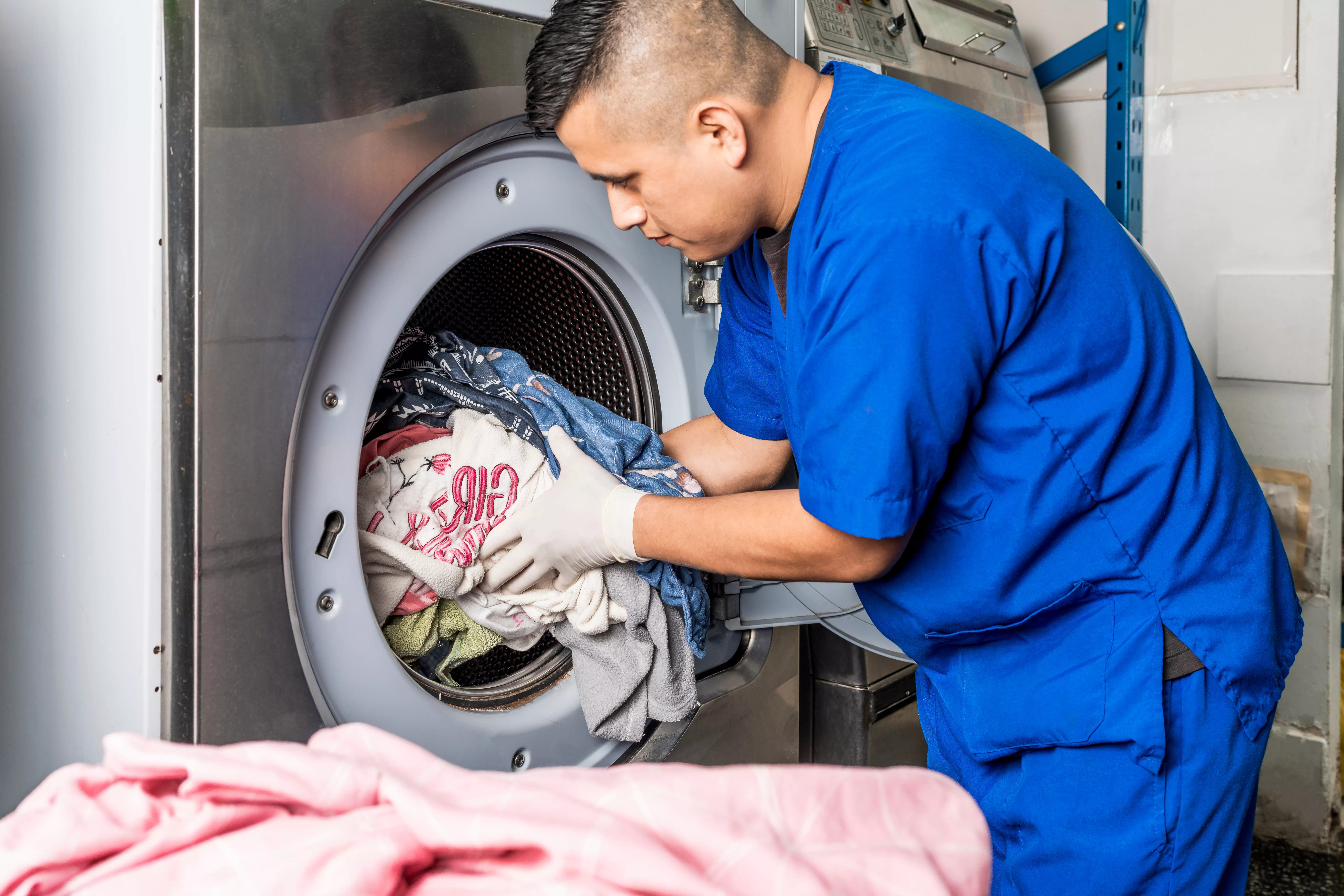aged care working loading a washing machine