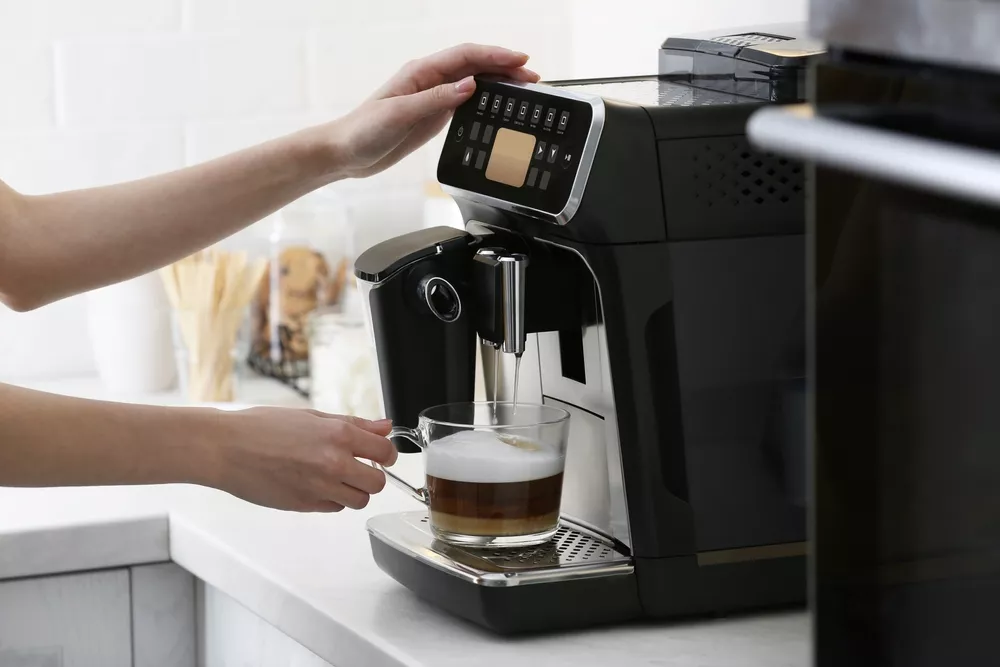 Woman using coffee maker at home