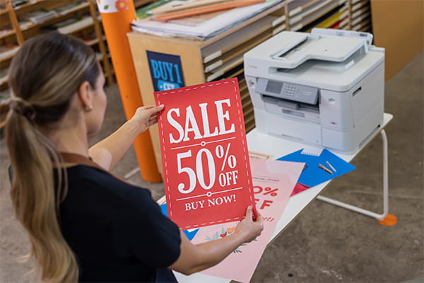 woman looking at sale banner print-out