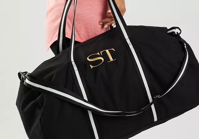 image of a person carrying a monogramed sports bag.
