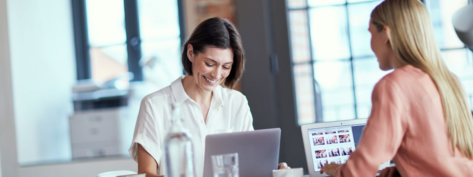 two ladies sitting at a desk smiling