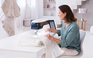 Image of a lady at the Brother Aveneer in sewing mode