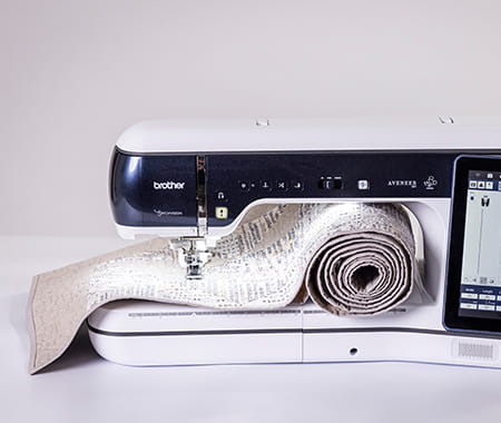 Image of the Brother Aveneer EV1 with a large quilt rolled in the throat space