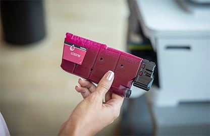 person holding magenta ink cartridge