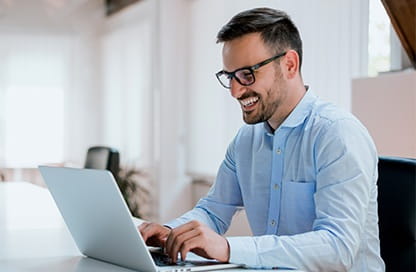 man smiling at his laptop
