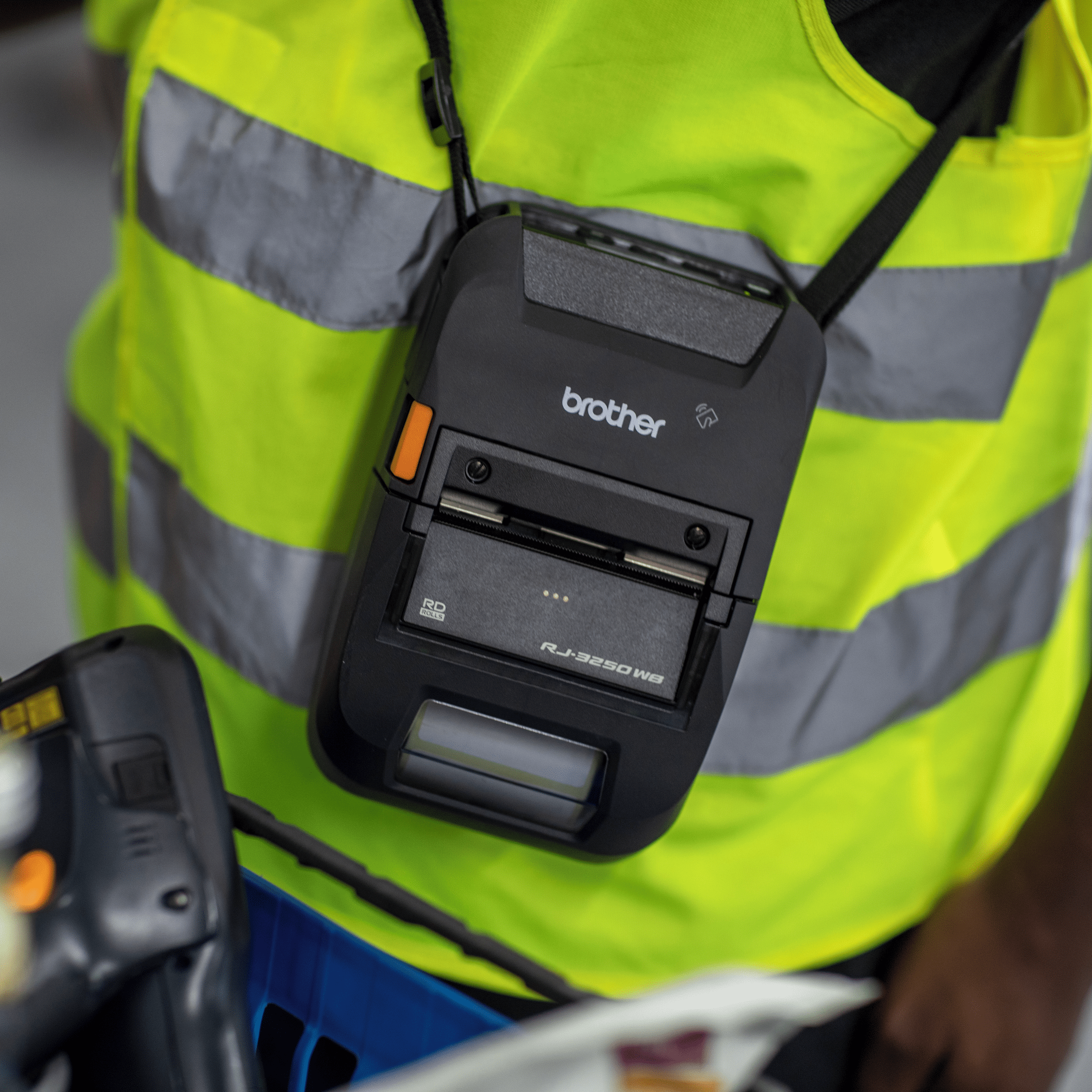 portable printer brother rj-3230b being used with a shoulder strap by a person in high vis