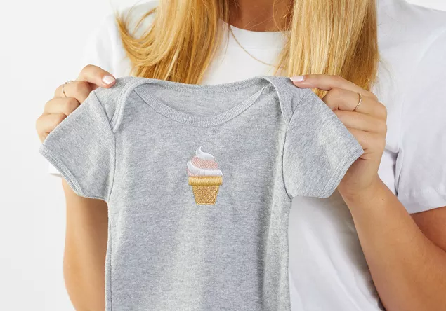 image of an machine embroidery design on the front of a babies onesie