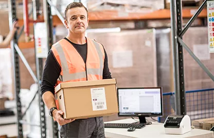 man carrying package in warehouse