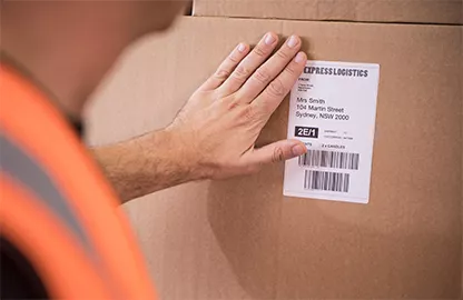 man sticking label onto package