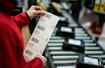 man holding a strip of printed labels