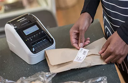 hand sticking a label onto package