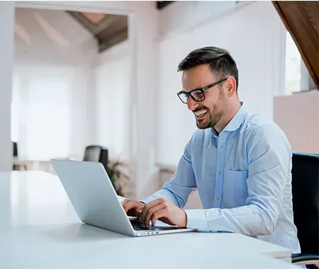 man smiling at his laptop