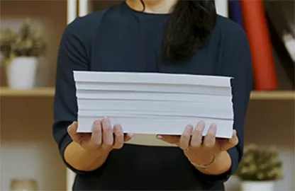 woman holding a stack of print-outs