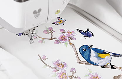 Image of a built in embroidery design in the hoop of a Brother Stellaire2 Innov-is XE2 Embroidery machine depicting a bird, butterflies and a Cherry Blossom Branch with flowers