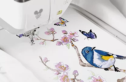 Image of a built in embroidery design in the hoop of a Brother Stellaire2 Innov-is XE2 Embroidery machine depicting a bird, butterflies and a Cherry Blossom Branch with flowers