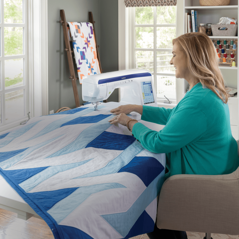 Quilter using the Brother BQ3100 to sew a large modern quilt