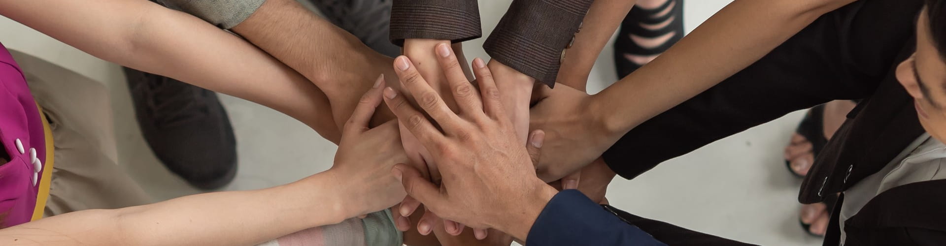 Team huddle with hands joined together.