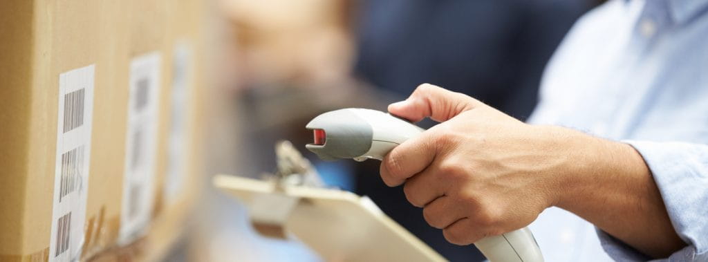 A warehouse worker scanning a barcode on a product carton.