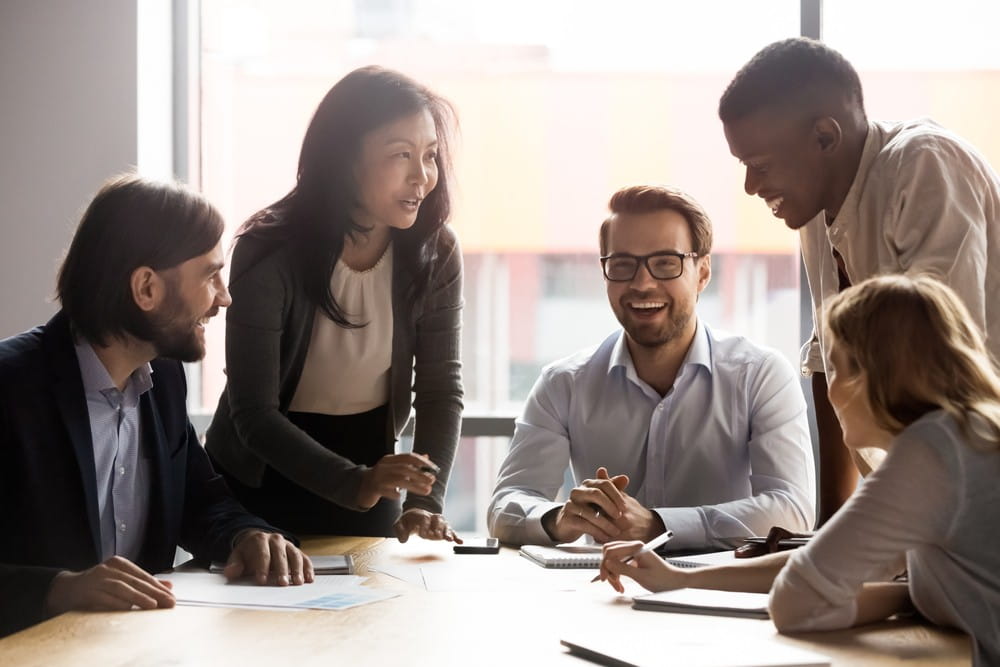 A group of diverse office workers in a boardroom. 