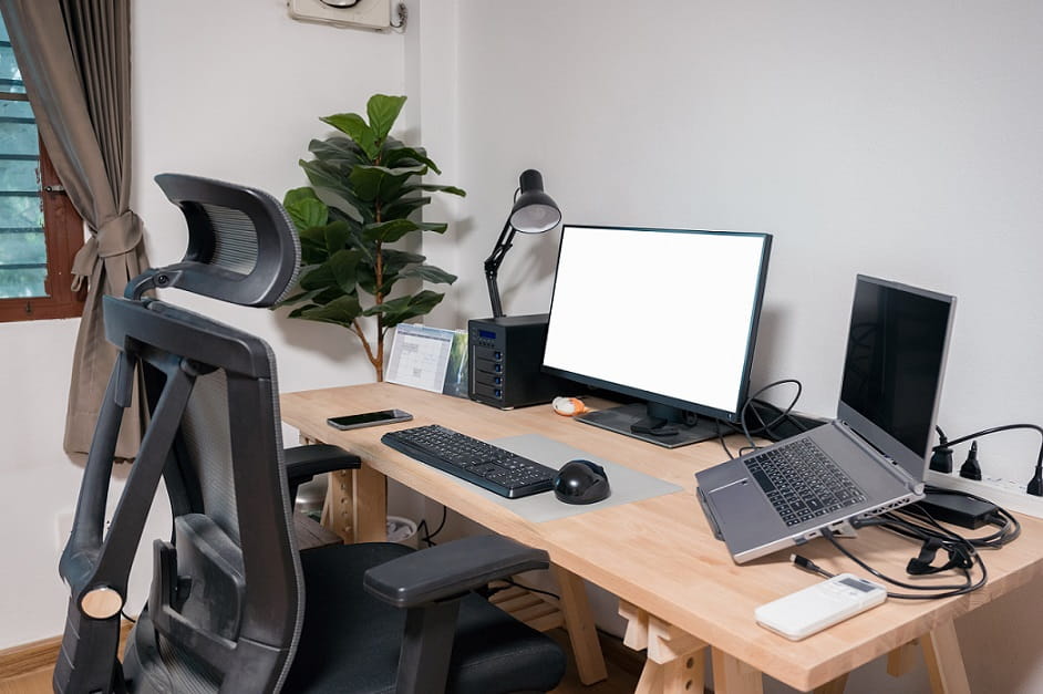 Desktop and Laptop on a wooden desk setting with good ergonomics